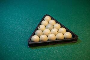 Billiards balls in a triangle on a green table photo