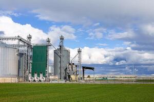 A large grain silo with a green field in front of it photo