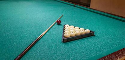 A billiard table with balls and a stick photo