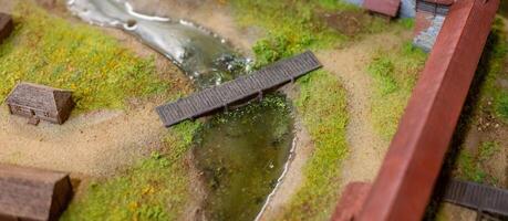 A model of a small town with a bridge over a river photo