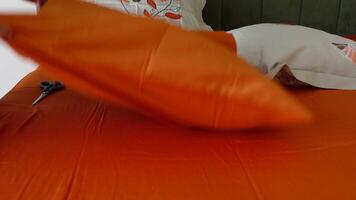 Tips for making a bed with an orange sheet set video
