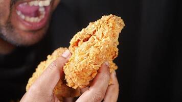 Enjoying crispy fried chicken in a home kitchen setting video