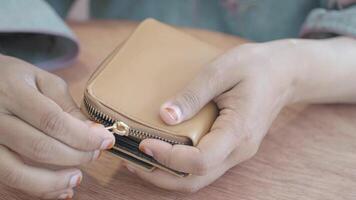 Hands opening a wallet in a cozy indoor setting video