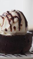 Delicious dessert with chocolate sauce and ice cream in a cozy setting video