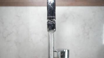 Water flows from modern faucet in a sleek kitchen setup video