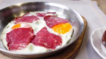 Tasty breakfast of eggs and cured meat in a cozy setting video