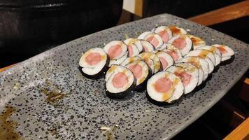 Sushi rolls made with fresh fish are expertly arranged for customers video