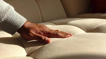 A hand gently presses down on a soft sofa . video