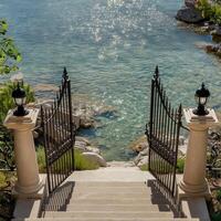 Open ornate gates leading down stone steps to clear water photo
