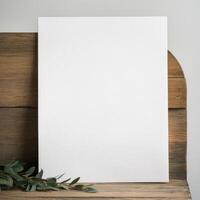 Blank white vertical canvas on rustic wood with eucalyptus leaves photo