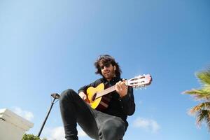 Senior Man Plays Classical Guitar On A Day Stand In The Park photo