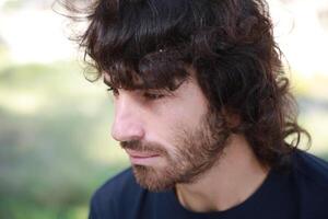 Sad Long Hair Man Is About To Cry From Depression In The Nature Park close up shot photo