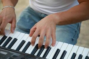 Hands Of A Young Man Play The Musical Keyboard Crossing In Rhythm In The Countryside photo
