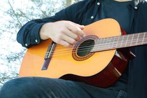 Playing the Guitar Outdoor to Train the Mind for Concentration and Exercise Close up photo
