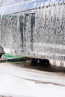 Car washing process showing foam and water dripping at a vehicle detailing location photo