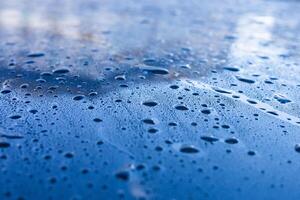 Water droplets accumulate on a blue surface after rainfall during the early morning hours photo