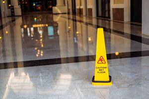 Caution sign indicating wet floor in a modern indoor corridor photo