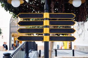 Directional signpost with multiple blank arrows in an urban setting during daylight hours photo