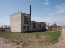 An old and abandoned industrial building remains isolated in a serene and peaceful rural environment photo