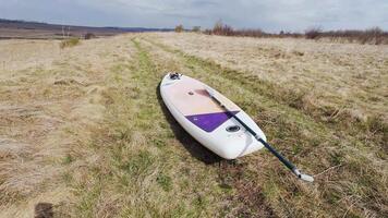 A paddleboard sits in the middle of a field video