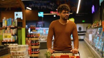 Smiling Arab man with cart in grocery store aisle video