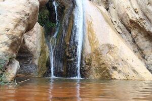 a waterfall in the middle of a canyon photo