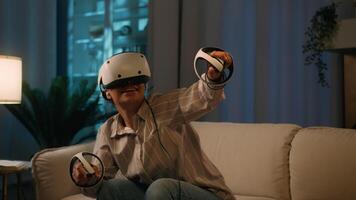 African American woman in VR helmet play virtual reality game happy amazed girl use controllers gaming simulation have fun playing with 3D goggles at night home metaverse cyberspace modern technology video