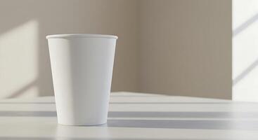 A white cup sitting on a table in front of a window photo
