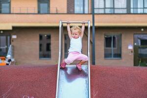 A little girl playing and sliding down a slide photo