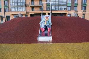A young child is sliding down a slide at a playground photo