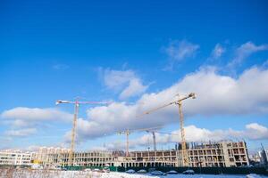 A construction site with cranes and a cloudy sky photo