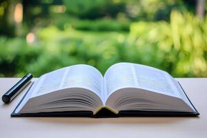 Open book lying on table with blurred green background photo