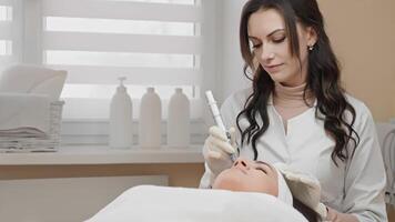 In a modern clinic, a skilled cosmetologist performs an advanced skincare procedure using innovative techniques and equipment, all while fostering a calming ambiance for relaxation video