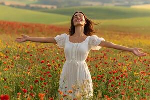 Beautiful woman enjoying freedom in poppy field with open arms photo