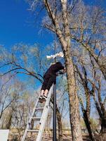 Worker installing security cameras and megaphone on lamp post photo