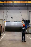 Pipe on overhead crane. Worker with remote control photo