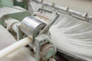 Wool fibers enter a carding machine at a textile plant for further yarn production. photo