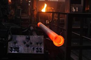 Freshly cast red hot iron pipe at the foundry.. photo