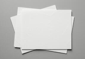 Three blank white paper sheets on a gray background photo