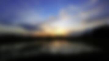 Abstract Sunrise Blurred Image with Water Reflection and Blue Sky photo