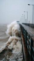 Powerful waves crash against pier during stormy day photo