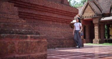 Handheld low angle view shot, Solo Asian tourist enjoys strolling around to appreciate the serene surroundings and the cultural richness of the place. Traveling and vacation concept video