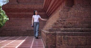 Handheld low angle view shot, Female tourist enjoys strolling around to appreciate the serene surroundings and the cultural richness of the place. Traveling and vacation concept video