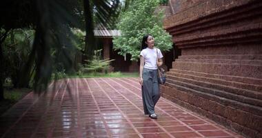 Handheld shot, Solo woman tourist enjoys strolling around to appreciate the serene surroundings and the cultural richness of the place. Traveling and vacation concept video