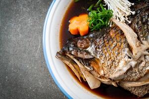 Boiled Fish Head with Soy Sauce on dark background photo