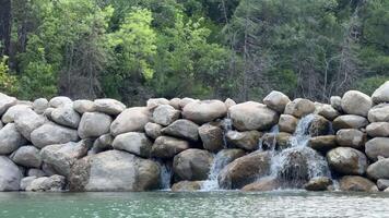 Small waterfall and mountain river in the forest. azure water. video