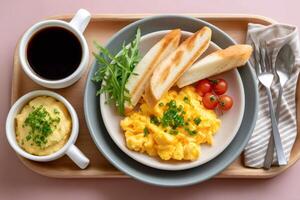 Scrambled eggs with toast, salad, mashed potatoes and coffee served on wooden tray for breakfast photo