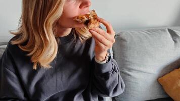 Closeup of woman biting pizza, warm textures and cheesy pull in full focus, closeup creates intimate food connection, closeup delivers sensory engagement. Mouth centered view perfect for food branding video