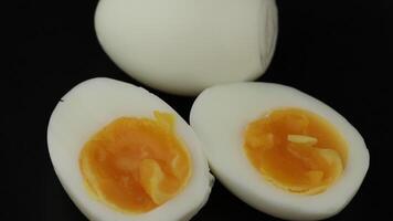 Soft boiled eggs with bright yellow yolks displayed on a dark background video