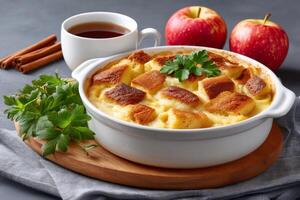 Apple bread pudding with cinnamon sticks and teacup photo